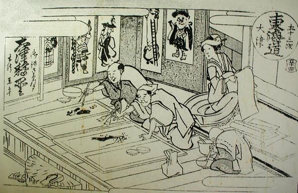 Familia japonesa colaborando en la producción de otsu-e, siglo XIX