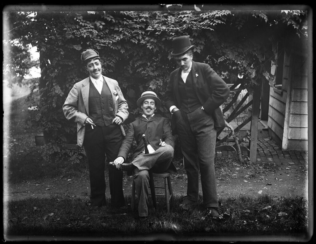 Alice Austen. Julia Martin, Julia Bredt and self dressed up, sitting down, 1891